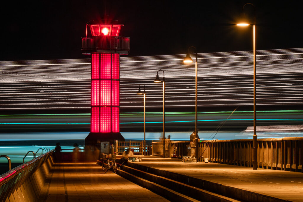 フェリーが横切る夜の高松港の赤灯台